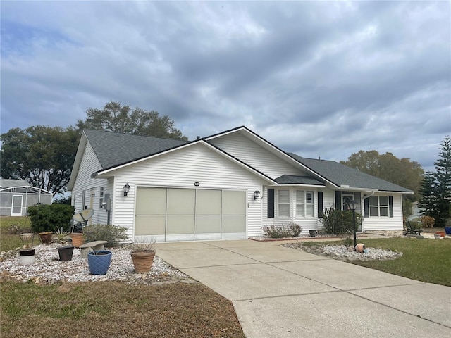 ranch-style home with a shingled roof, concrete driveway, and an attached garage