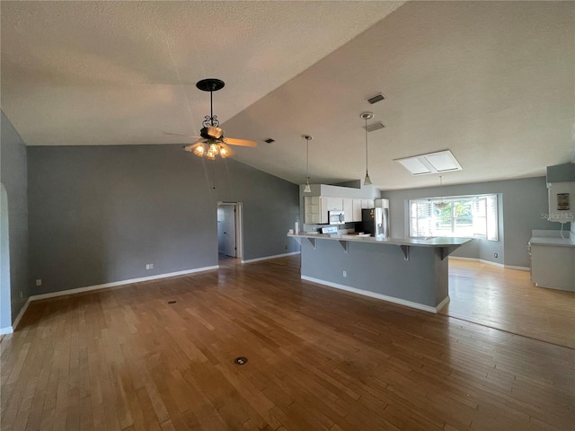 kitchen with open floor plan, stainless steel appliances, visible vents, and light wood-style floors