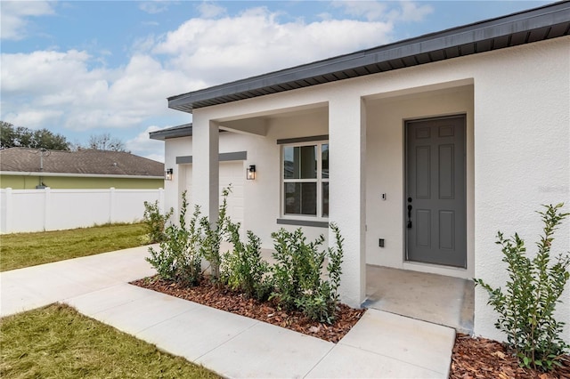 entrance to property with a garage and a lawn