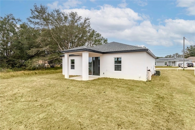 back of house featuring a yard, central AC unit, and a patio area