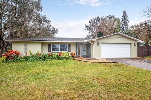 single story home featuring a front lawn and a garage