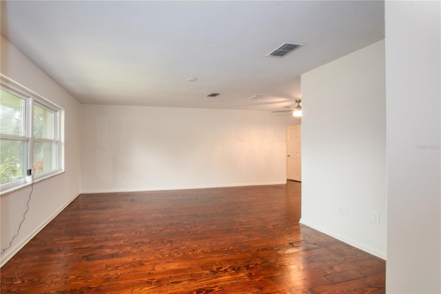 unfurnished room with dark wood-type flooring and ceiling fan