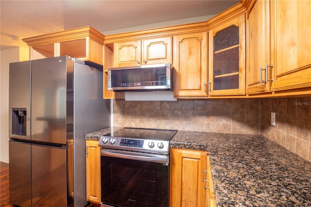 kitchen featuring decorative backsplash, dark stone countertops, and stainless steel appliances