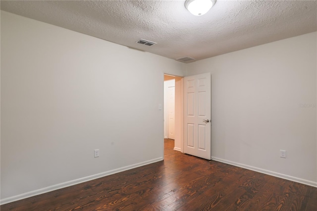 unfurnished room featuring a textured ceiling and dark hardwood / wood-style flooring