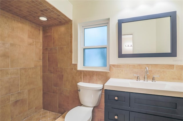 bathroom featuring toilet, vanity, tile walls, and tiled shower