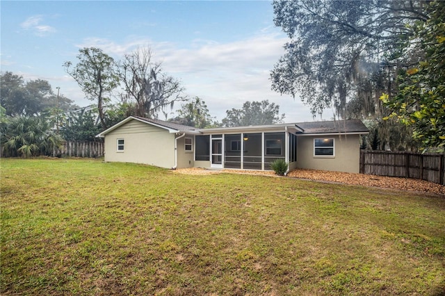 back of house featuring a yard and a sunroom