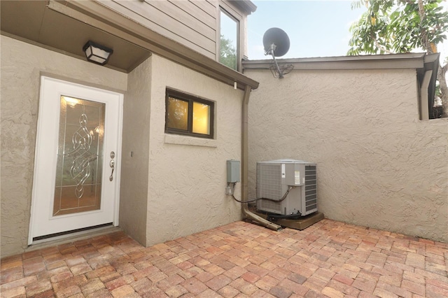 entrance to property with central air condition unit and a patio area