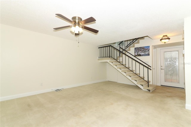 unfurnished living room featuring carpet flooring and ceiling fan