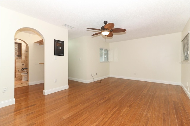 empty room featuring hardwood / wood-style floors, ceiling fan, and a textured ceiling