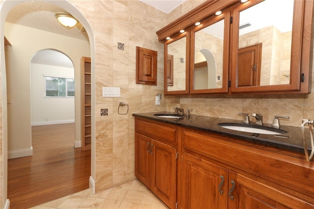 bathroom featuring tasteful backsplash, a textured ceiling, vanity, tile walls, and hardwood / wood-style flooring