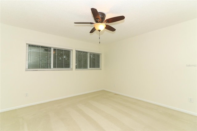 carpeted empty room with ceiling fan and a textured ceiling