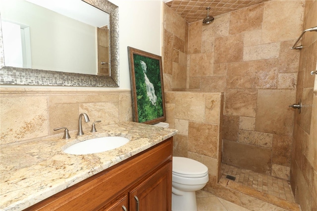 bathroom featuring a tile shower, decorative backsplash, vanity, and toilet