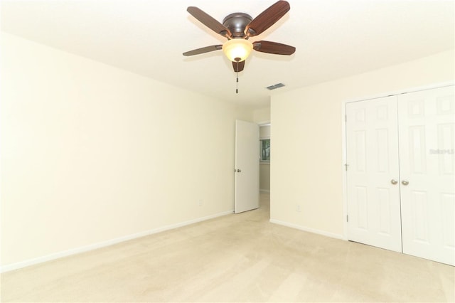 unfurnished bedroom with ceiling fan, a closet, and light colored carpet