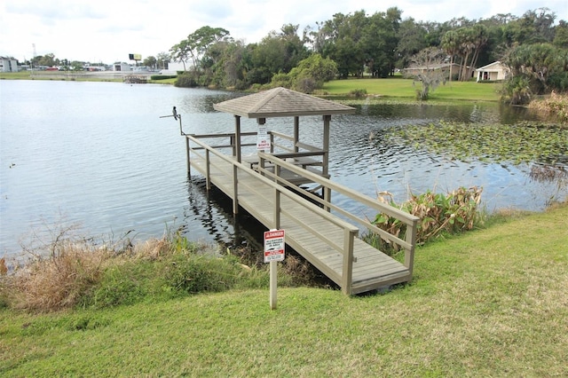 dock area with a water view and a lawn