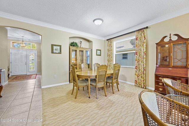 dining area featuring ornamental molding, an inviting chandelier, a textured ceiling, and light tile patterned flooring