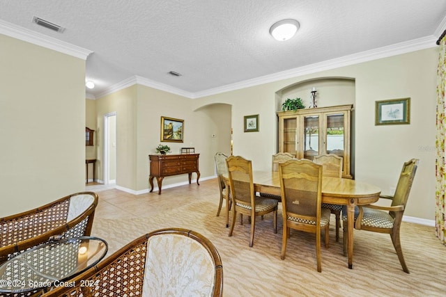 tiled dining room with crown molding and a textured ceiling