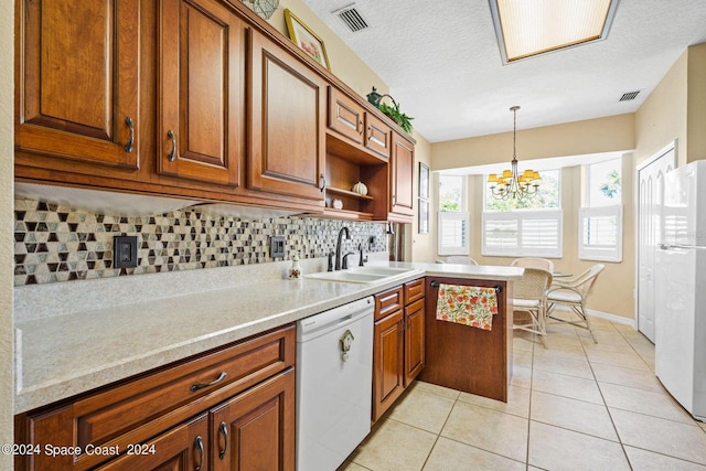 kitchen with white appliances, sink, pendant lighting, decorative backsplash, and an inviting chandelier