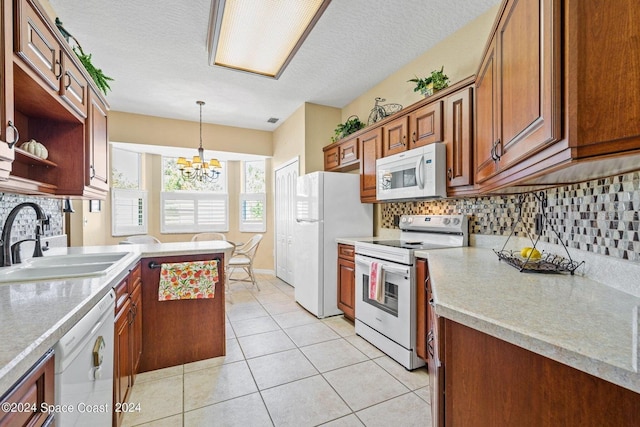 kitchen featuring sink, decorative light fixtures, an inviting chandelier, a textured ceiling, and white appliances