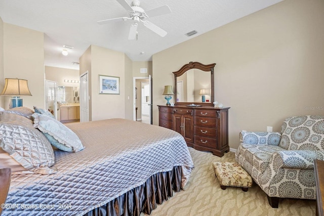 bedroom featuring connected bathroom, light carpet, a textured ceiling, and ceiling fan