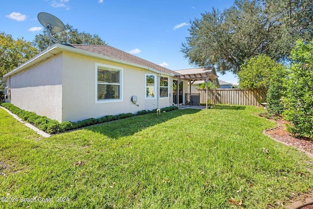 back of property with a lawn and a pergola