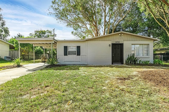 view of front facade featuring a front yard, central AC, and a carport