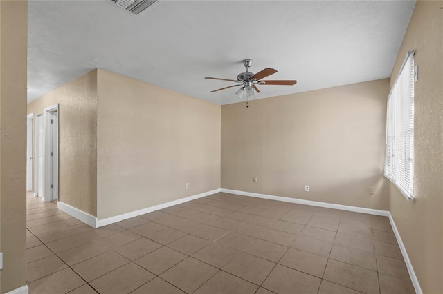 empty room with ceiling fan and light tile patterned floors