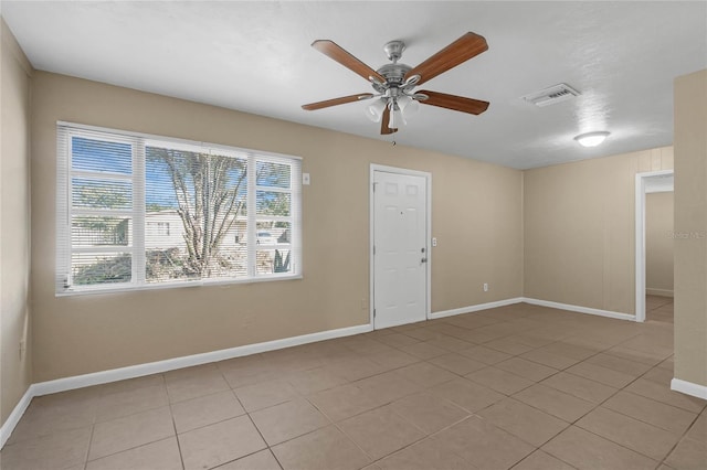 tiled spare room featuring ceiling fan