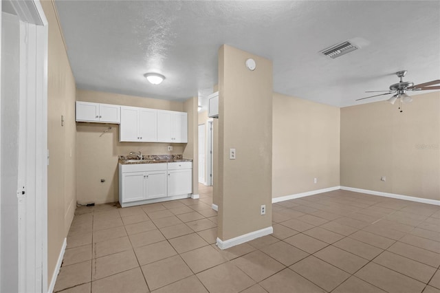 kitchen with white cabinets, ceiling fan, light tile patterned floors, and sink