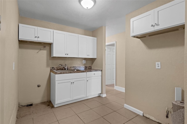 kitchen featuring white cabinetry, sink, and light tile patterned floors