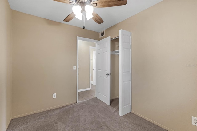 unfurnished bedroom featuring ceiling fan, light carpet, and a closet