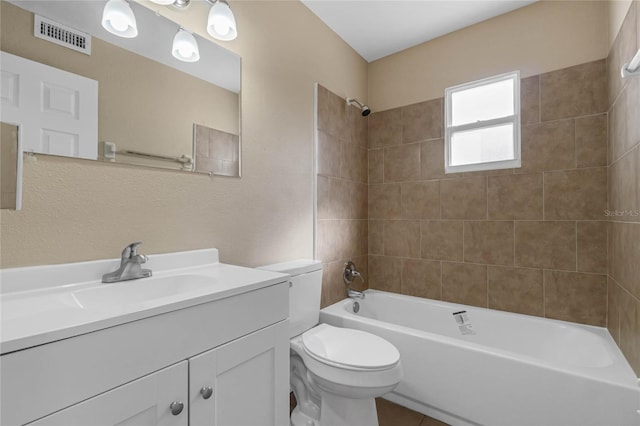 full bathroom with vanity, tiled shower / bath, and toilet