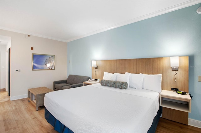 bedroom featuring ornamental molding and light wood-type flooring