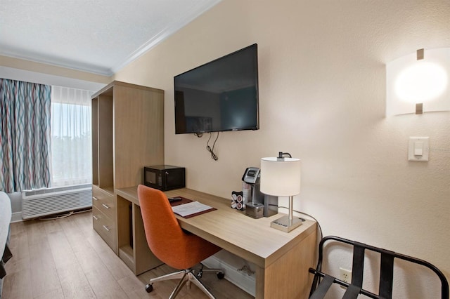 office area featuring an AC wall unit, ornamental molding, and light hardwood / wood-style flooring