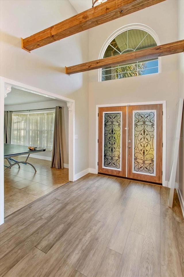 entrance foyer with french doors, light hardwood / wood-style floors, and high vaulted ceiling