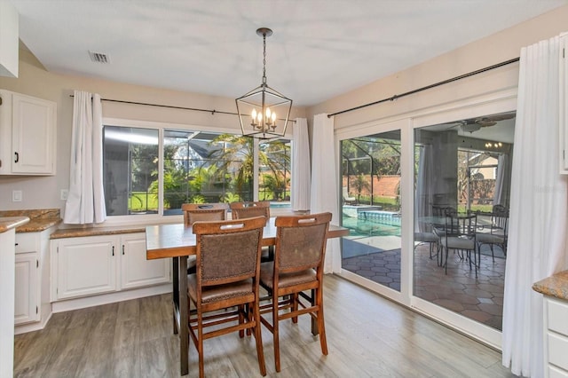 dining room with hardwood / wood-style floors and a notable chandelier