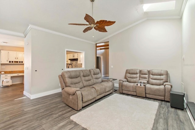 living room featuring ceiling fan, wood-type flooring, vaulted ceiling, and ornamental molding