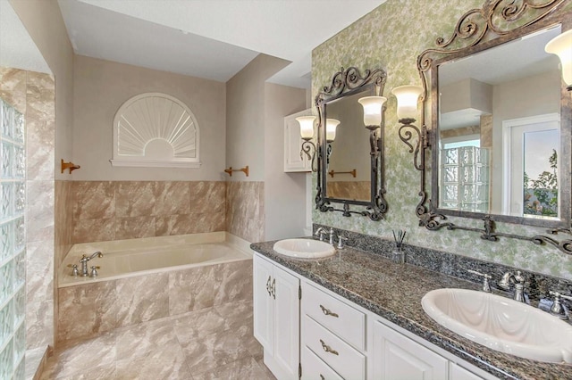 bathroom featuring vanity and tiled bath