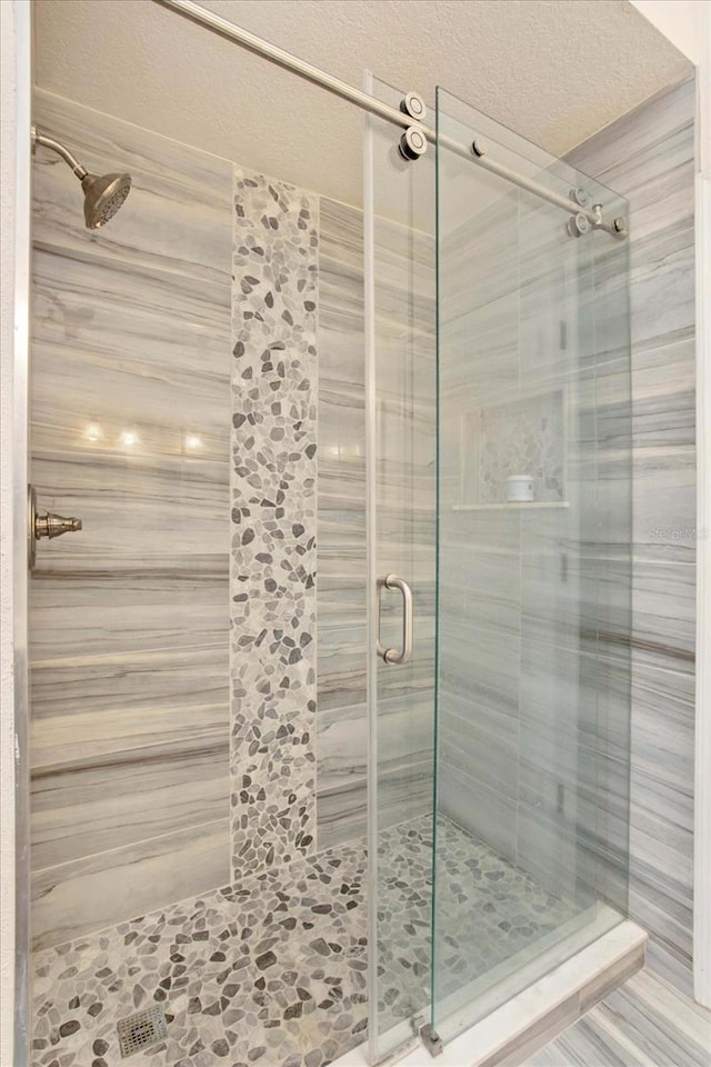 bathroom featuring a textured ceiling and an enclosed shower