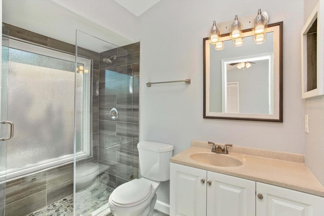 bathroom with toilet, a shower with shower door, and vanity