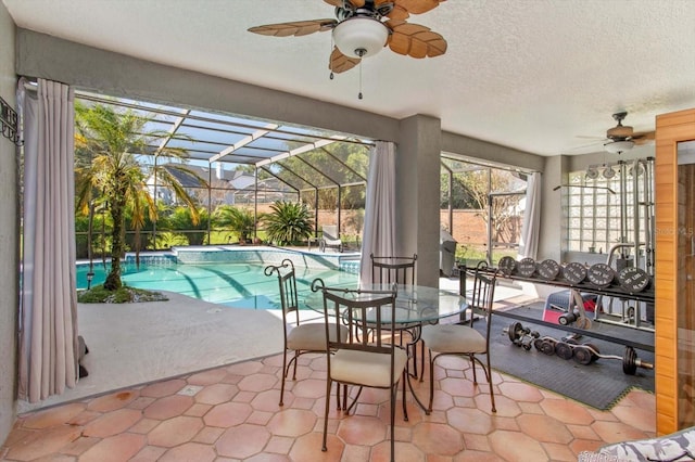 sunroom featuring a pool and ceiling fan