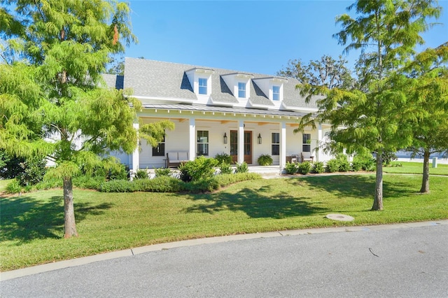 cape cod-style house with a front yard and covered porch