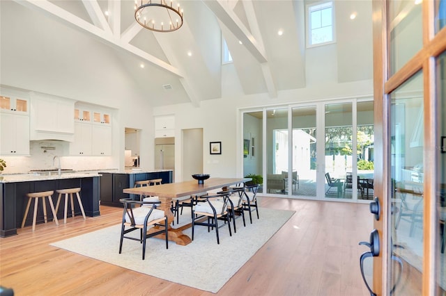 dining room with beamed ceiling, light wood-type flooring, high vaulted ceiling, and a healthy amount of sunlight