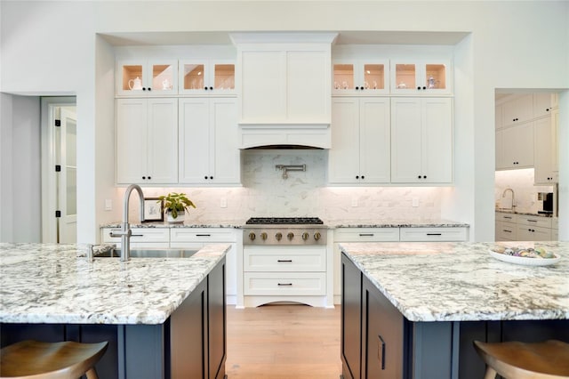 kitchen with white cabinets, a kitchen bar, and stainless steel gas cooktop