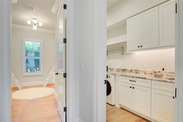 bathroom featuring washer / dryer, crown molding, wood-type flooring, and vanity