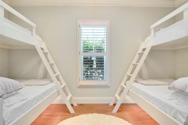 bedroom with crown molding and wood-type flooring