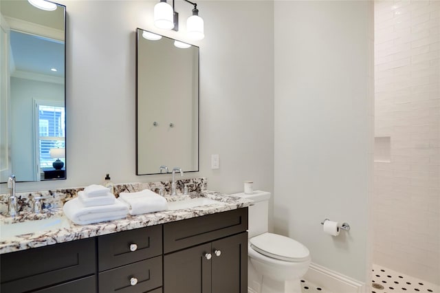 bathroom with toilet, tiled shower, vanity, crown molding, and tile patterned flooring