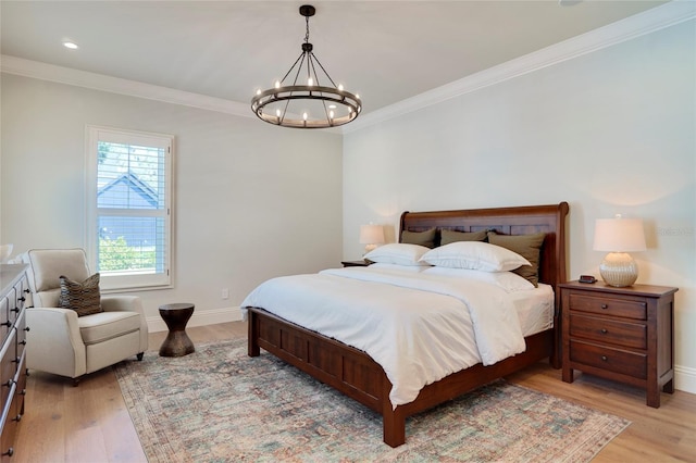 bedroom with crown molding, light hardwood / wood-style flooring, and an inviting chandelier