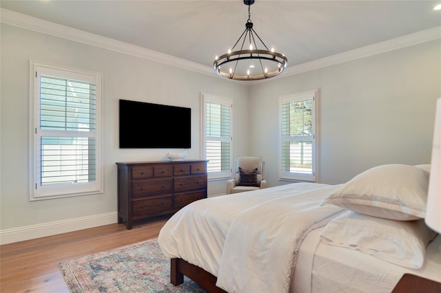 bedroom with light hardwood / wood-style floors, ornamental molding, and a chandelier