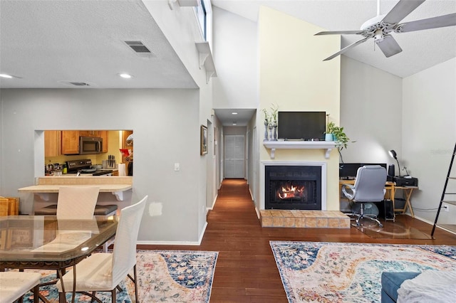 living room featuring ceiling fan, a textured ceiling, high vaulted ceiling, and dark hardwood / wood-style flooring