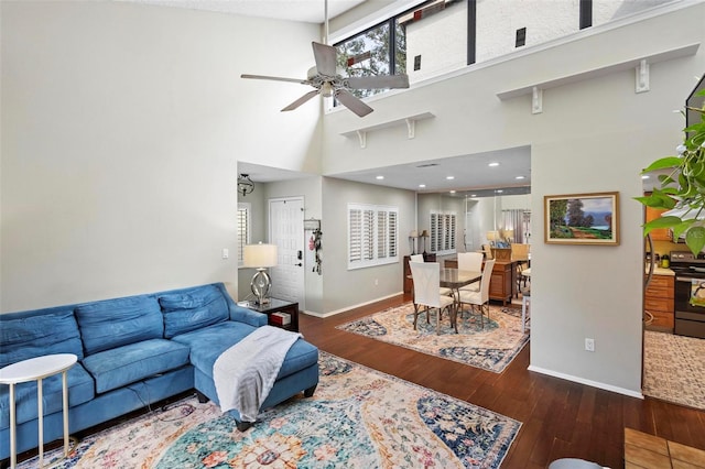 living room with dark hardwood / wood-style floors, high vaulted ceiling, and ceiling fan